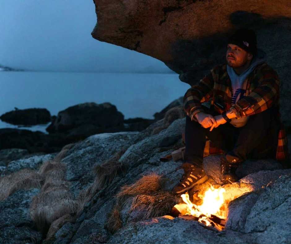 Managing stress: 20 best ways to relieve stress - Man sitting by campfire